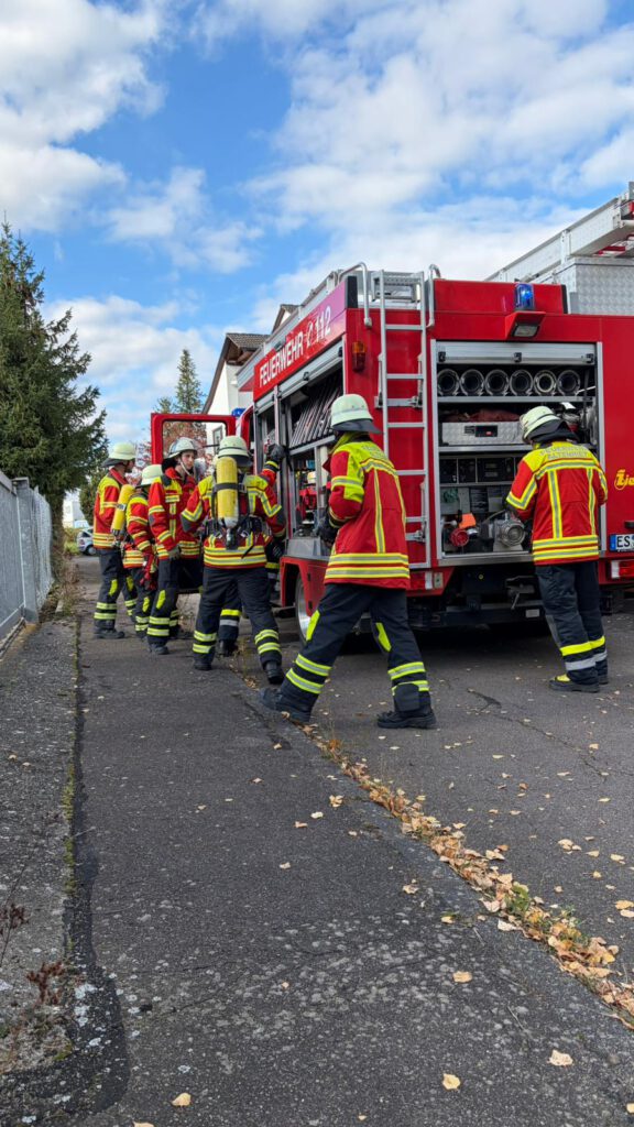 Die Trupps der Feuerwehr Altenriet bewegen sich um das Löschgruppenfahrzeug 10 um aus den Geräteräumen Material für die Brandbekämpfung zu holen.