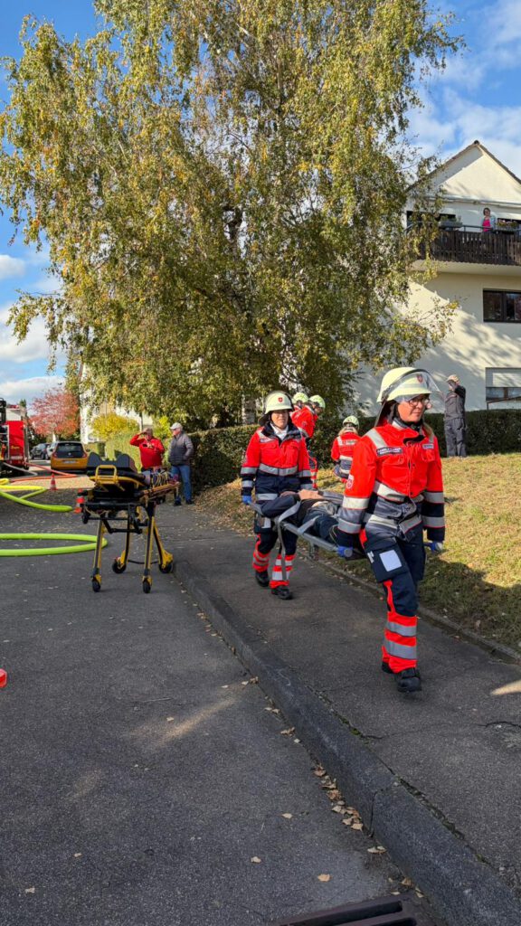 Die Malteser versorgten die Patienten. Auf dem Bild sind zwei Personen von den Maltesern zu sehen, welche zusammen eine Trage mit einer verletzten Person darauf tragen.