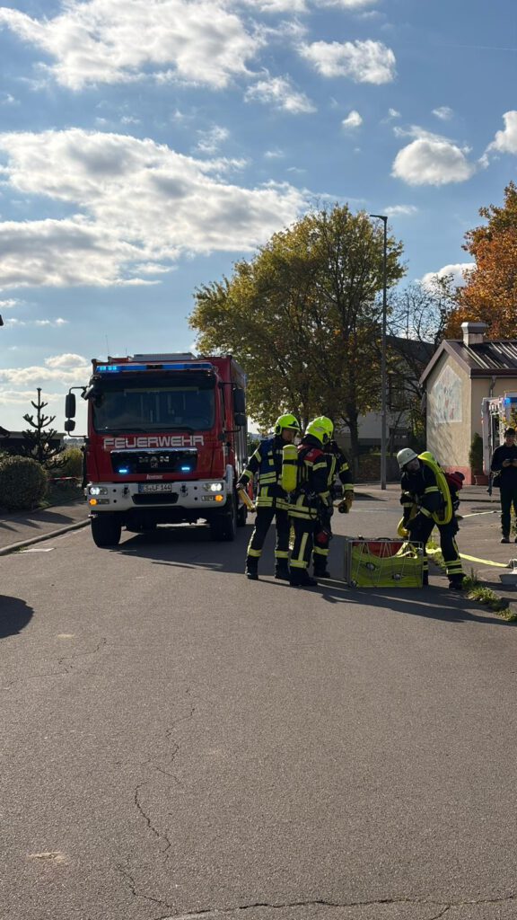 Der Sicherheitstrupp der FF Bempflingen erhält vom Gruppenführer Befehle. 
Auf dem Bild sind mehrere Feuerwehrleute zu sehen. Ein Trupp erhält Befehle vom Gruppenführer. Eine weitere Person kümmert sich um das Schlauchmanagement.