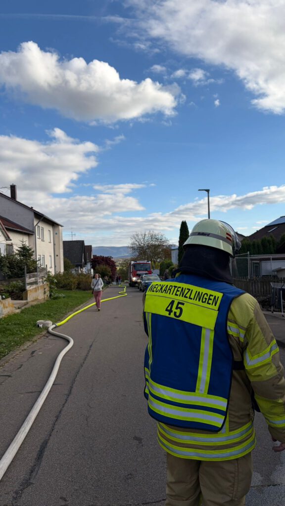 Gruppenführer der FF Neckartenzlingen. Auf der Straße sieht man die Schlauchleitung vom Löschwasserbehälter.
Auf dem Bild ist ein Gruppenführer von hinten zu sehen. Auf der Straße liegt eine lange Schlauchleitung, welche von einem Löschwasserbehälter verlegt wurde.
